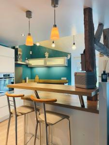 a kitchen with a table and two stools at Gîte "Au Fourneau" in Spa