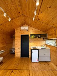 a kitchen with wooden walls and a wooden floor at Nordic Cabanas in Cambara do Sul