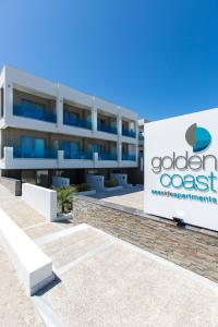 a large building with a sign on the side of it at Golden Coast Seaside Apartments in Rethymno