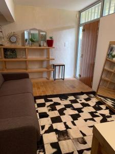 a living room with a couch and a checkered floor at Studio indépendant /2 personnes in Le Bugue