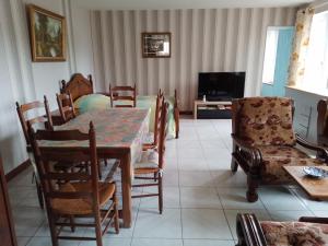 a dining room with a table and chairs and a television at Résidence ALEXIA in Saint-Valery-en-Caux