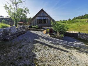 a barn with a gravel driveway in front of it at Farm Stay Ana in Višnja Gora