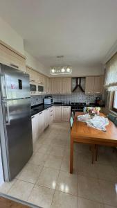 a kitchen with a wooden table and a stainless steel refrigerator at Heaven Garden Villa in Trabzon