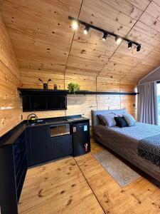 una camera da letto con un letto in una stanza con pareti in legno di Nordic Cabanas a Cambará