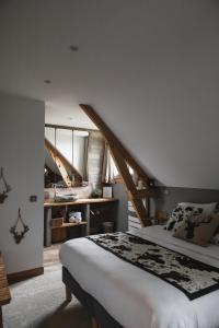 a bedroom with a large bed and a large window at La Bastide de Barbizon in Barbizon