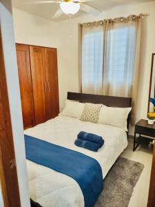 ein Schlafzimmer mit einem großen Bett mit einer blauen Decke in der Unterkunft Comodas 3 Hab con piscina, Wifi 1er nivel in Santiago de los Caballeros