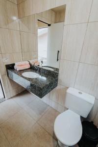 a bathroom with a white toilet and a sink at RECANTO DA SERRA in Mauá da Serra