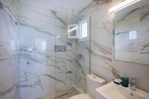 a bathroom with a shower and a toilet and a sink at Kahlenberg apartments in Afitos