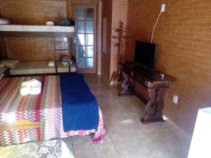 a living room with a tv and a desk with a television at Pousada luar da serra in Lumiar