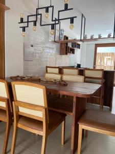 uma sala de jantar com uma mesa de madeira e cadeiras em Vilage Villa Andorinha - apt 09 em Mucugê