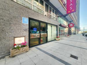 un edificio en una calle con flores en la acera en Hotel Faranda Express Alisas Santander, en Santander
