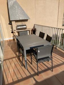 a table and chairs on a balcony with a grill at le Barcarès appartement bord de mer in Le Barcarès