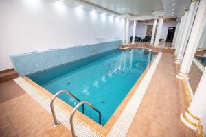 a large indoor swimming pool in a building at Amsterdam Hotel Aktobe in Aktobe