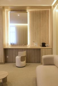 - un salon avec une chaise et un miroir dans l'établissement Amsterdam Hotel Aktobe, à Aqtöbe