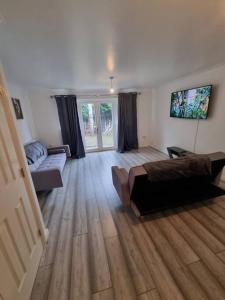 um quarto com uma cama e um sofá em Maidstone villa 3 bedroom free sports channels,parking em Kent