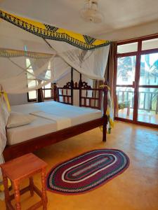 - une chambre avec un grand lit à baldaquin dans l'établissement Santa Maria Coral Park, à Pongwe
