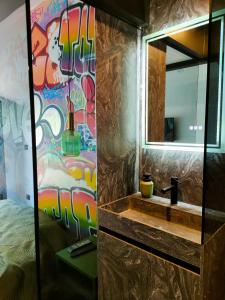 a bathroom with a sink and a mirror at Chambre Street Art in Capbreton