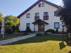 a white house with an umbrella in the yard at Apartmány Audy in Mníšek pod Brdy
