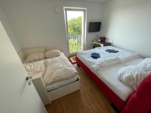 Duas camas num pequeno quarto com uma janela em Boutique Zimmer Privat 1-4 Personen em Frankfurt