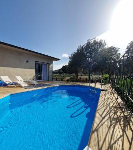 a swimming pool in front of a house at Domaine U Filanciu, Maison Ghjulia avec piscine - Centre Corse in Moltifao