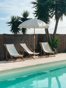two lounge chairs and an umbrella next to a swimming pool at Quinta Amarela - B&B in Nazaré