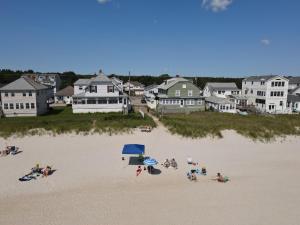 a group of people on a beach with houses at Patras Grand Beach Motel in Old Orchard Beach