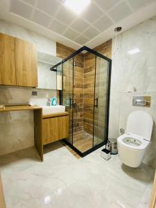 een badkamer met een toilet en een glazen douche bij KUSADASI SOGUCAKTA 2+1 TERASLI DENIZE YAKIN LUKS DAIRE in Kuşadası