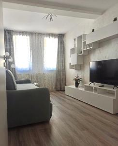 ein Wohnzimmer mit einem Sofa und einem Flachbild-TV in der Unterkunft Ferienwohnung Appartamento Da Vinci in Eisenach