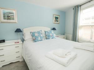 a bedroom with a white bed with towels on it at Lake Victoria Cottage in Dartmouth