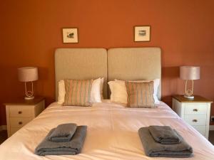 een slaapkamer met een groot bed en 2 handdoeken bij Seahorses Crail in Crail