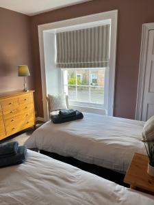 a bedroom with two beds and a window at Seahorses Crail in Crail