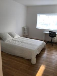 a bedroom with a bed and a desk and a window at GRENOBLE JOLI APPARTEMENT in Grenoble