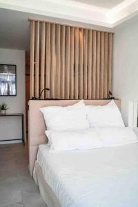 sypialnia z dużym łóżkiem z białymi poduszkami w obiekcie Suite luxe jacuzzi w Cannes