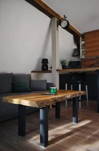 drewniany stół w salonie z kanapą w obiekcie Apartament Pruski Mur w Poznaniu