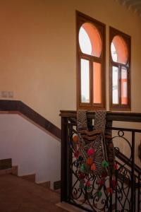 un escalier avec une balustrade en fer forgé et deux fenêtres dans l'établissement Dar Moulouya, à Marrakech