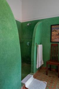 - une salle de bains verte avec une chaise et une serviette dans l'établissement Dar Moulouya, à Marrakech