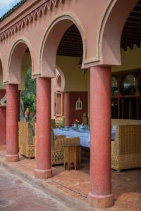 une terrasse avec des arches, une table et des chaises dans l'établissement Dar Moulouya, à Marrakech