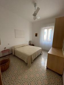 een witte slaapkamer met een bed en een raam bij Casa On The Beach in Alcamo