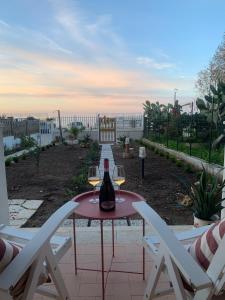 een tafel met twee glazen wijn op een patio bij Casa On The Beach in Alcamo