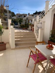 een patio met een tafel, stoelen en een trap bij Casa On The Beach in Alcamo