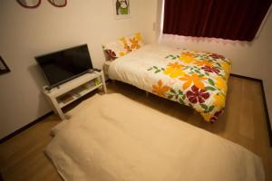 a bedroom with a bed and a flat screen tv at HOTEL LUCKY - Vacation STAY 49719v in Osaka