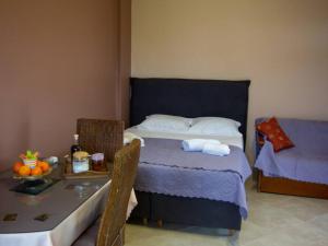 a bedroom with a bed and a table with a tableablish at Ktima Bavella Apartment Sophia 