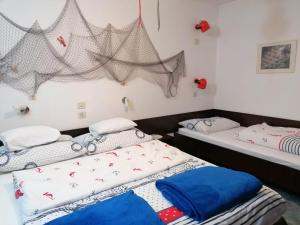 two beds in a room with nets on the wall at Apartments Misini Dvori in Stomorska