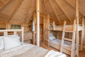 a bedroom with two bunk beds in a wooden cabin at Treehouse U rybníka in Osečná