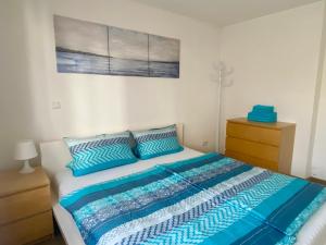 Un dormitorio con una cama con almohadas azules y una pintura en Ferienwohnung Allersberg, en Allersberg