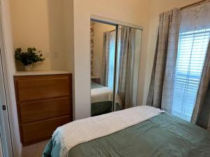 a bedroom with a bed and a dresser and a mirror at SLO Oasis Home in San Luis Obispo