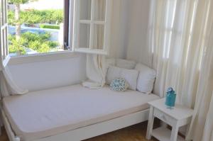 a white window seat in a room with a window view at ANIMA family apartment in Naxos Chora