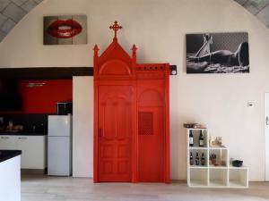 a red door in a kitchen next to a refrigerator at Studio avec jacuzzi terrasse amenagee et wifi a Ambrieres les Vallees in Ambrieres Les Vallees