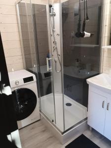 een badkamer met een douche en een wasmachine bij Nadmorska Sarbinowo in Sarbinowo