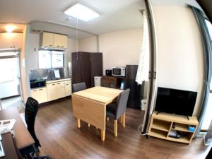 a living room with a table and a kitchen at Big stone tsukuda - Vacation STAY 14554 in Aomori